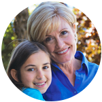 Grandmother and granddaughter hugging and smiling.